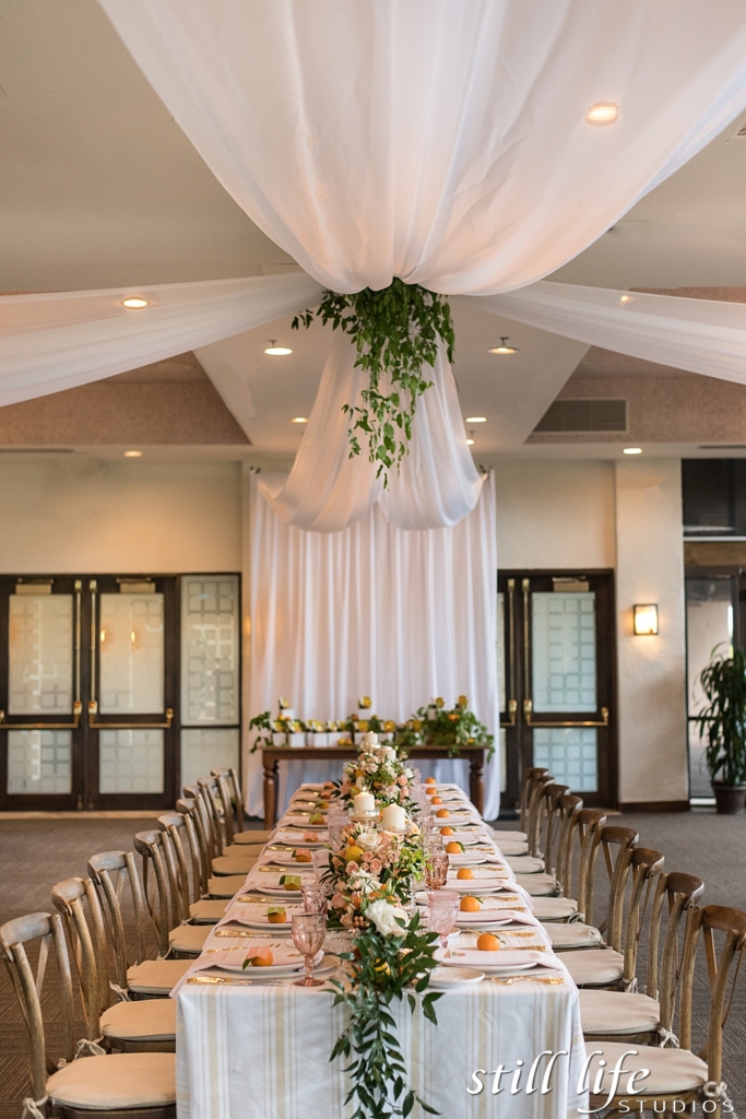 custom ceiling drape treatment for a wedding with white drape and greenery 