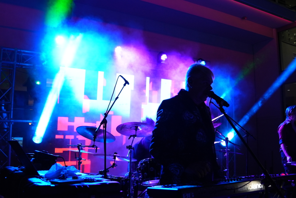 A/V Concert Production featuring colored lights, lead singer and guitar