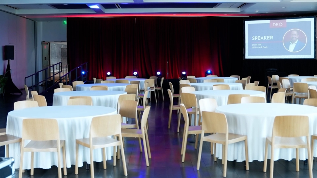 corporate event with audio visuals such as stage draping, projector and screen, and stage lighting