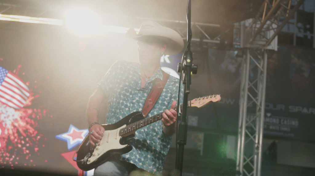 Guitar player at Westage Entertainment district concert on a stage with trussing and video wall 