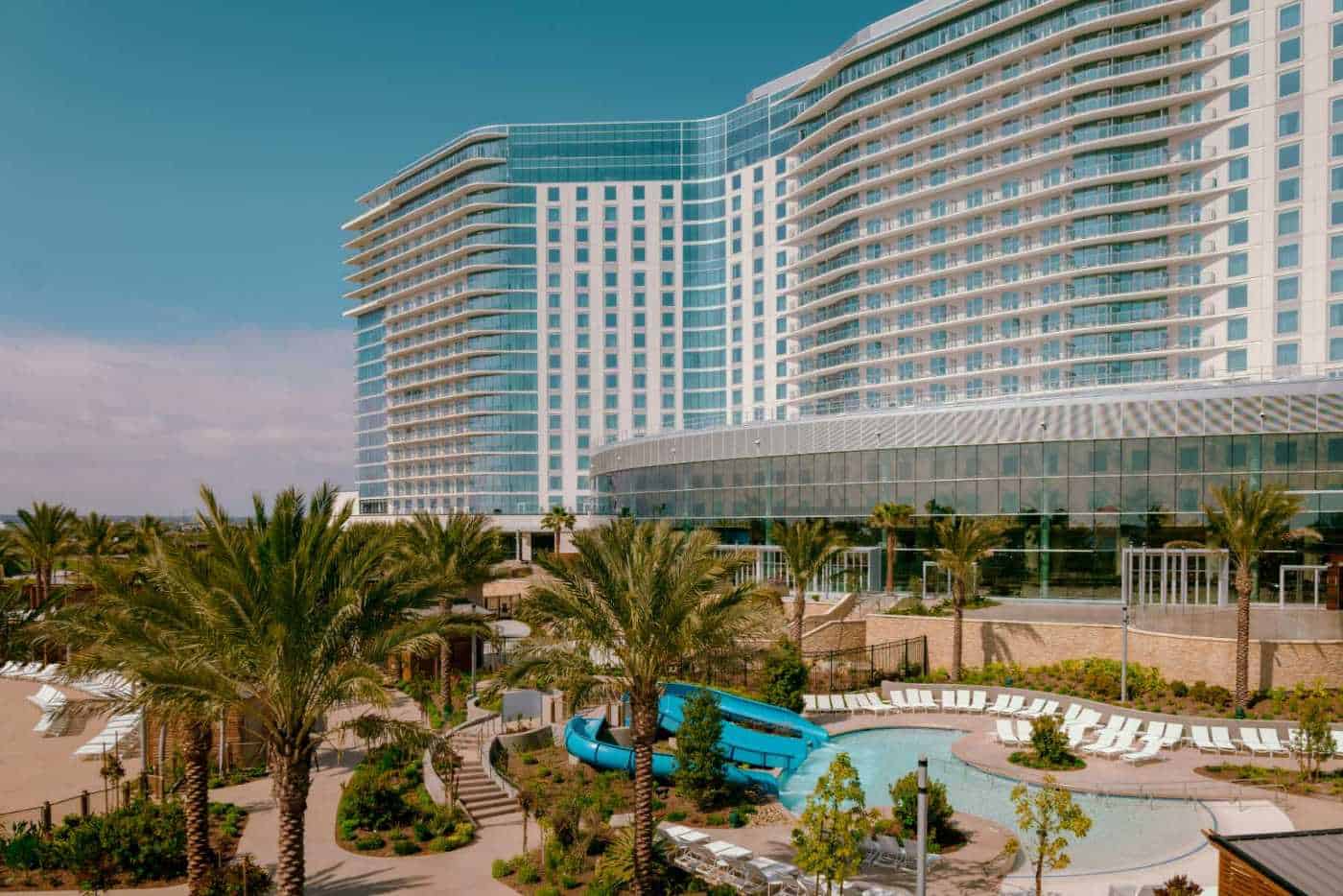 photo of the new Gaylord Pacific Resort & Convention Center in Chula Vista, CA showcasing a pool, palm trees, and tall shiny building.