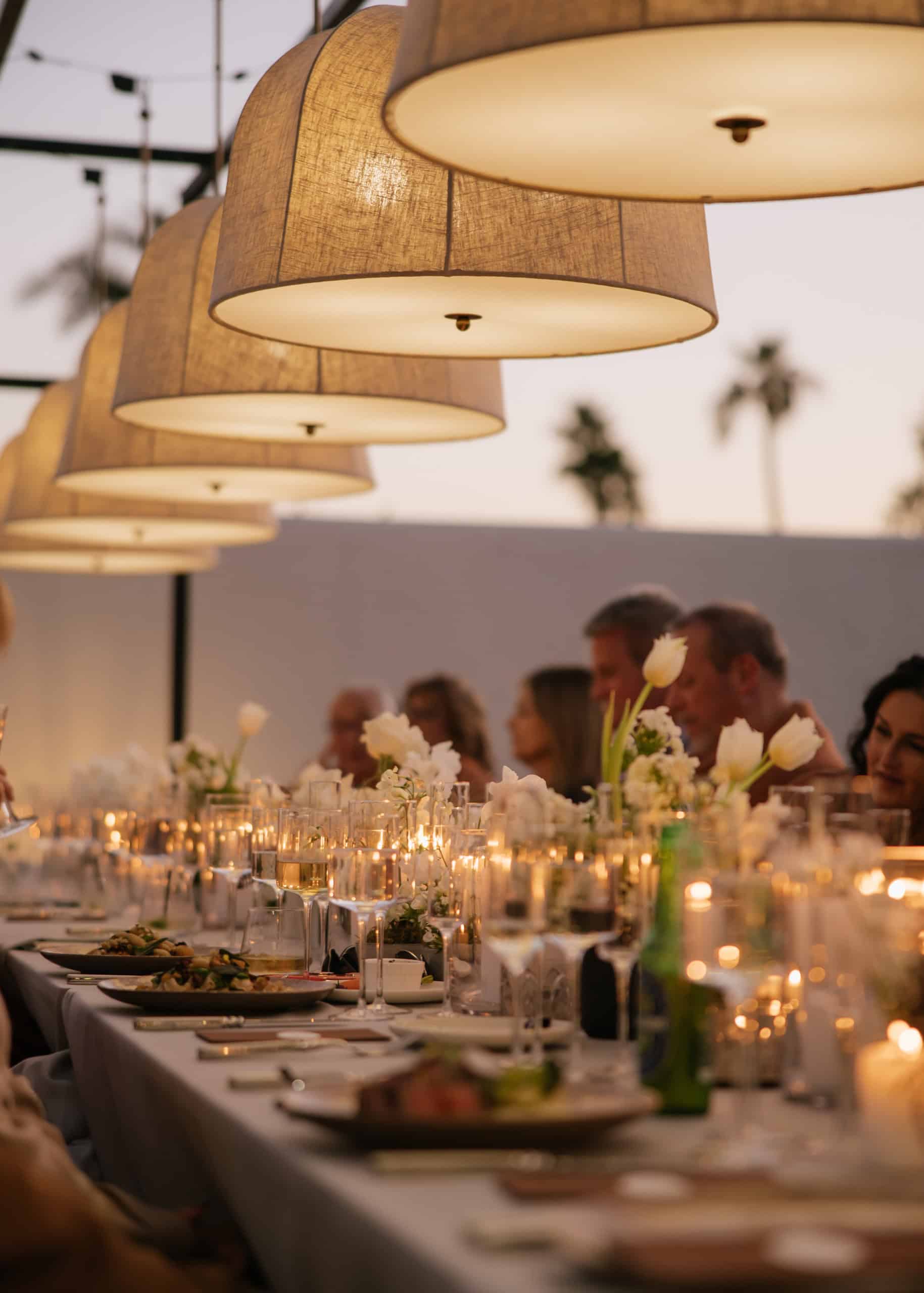 chandeliers over an elegant table at a luxury backyard wedding
