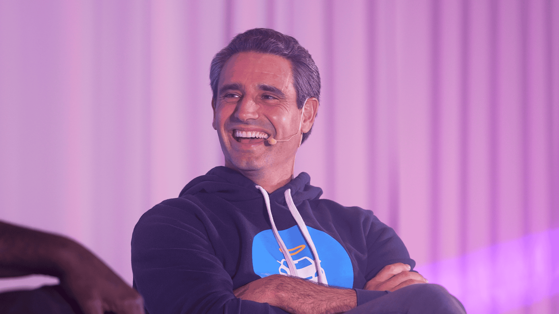 Ernest Garcia III, CEO of Carvana, on stage at the SPARK Conference with a professional over the ear headset microphone