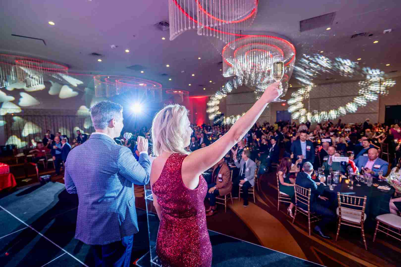 Executive accepting a Titan 100 Award on stage at Chateau Luxe, capturing the dynamic lighting and engaged audience.