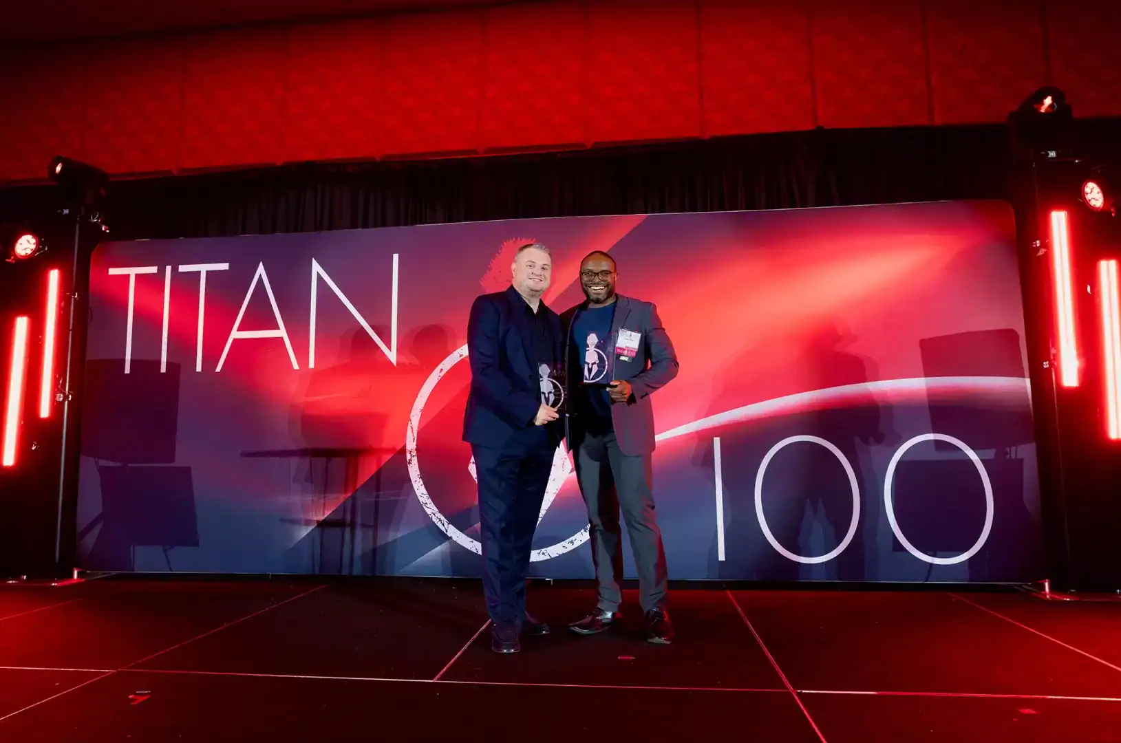 Attendee receiving a recognition award on the custom-produced Centric Events stage at Chateau Luxe.