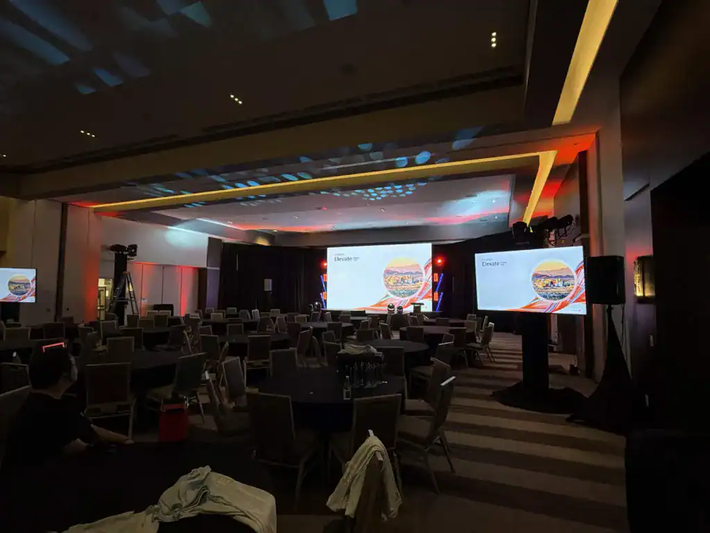 Corporate conference after-party at ADERO Scottsdale with a DJ, dance lighting, and a massive LED screen displaying karaoke lyrics.