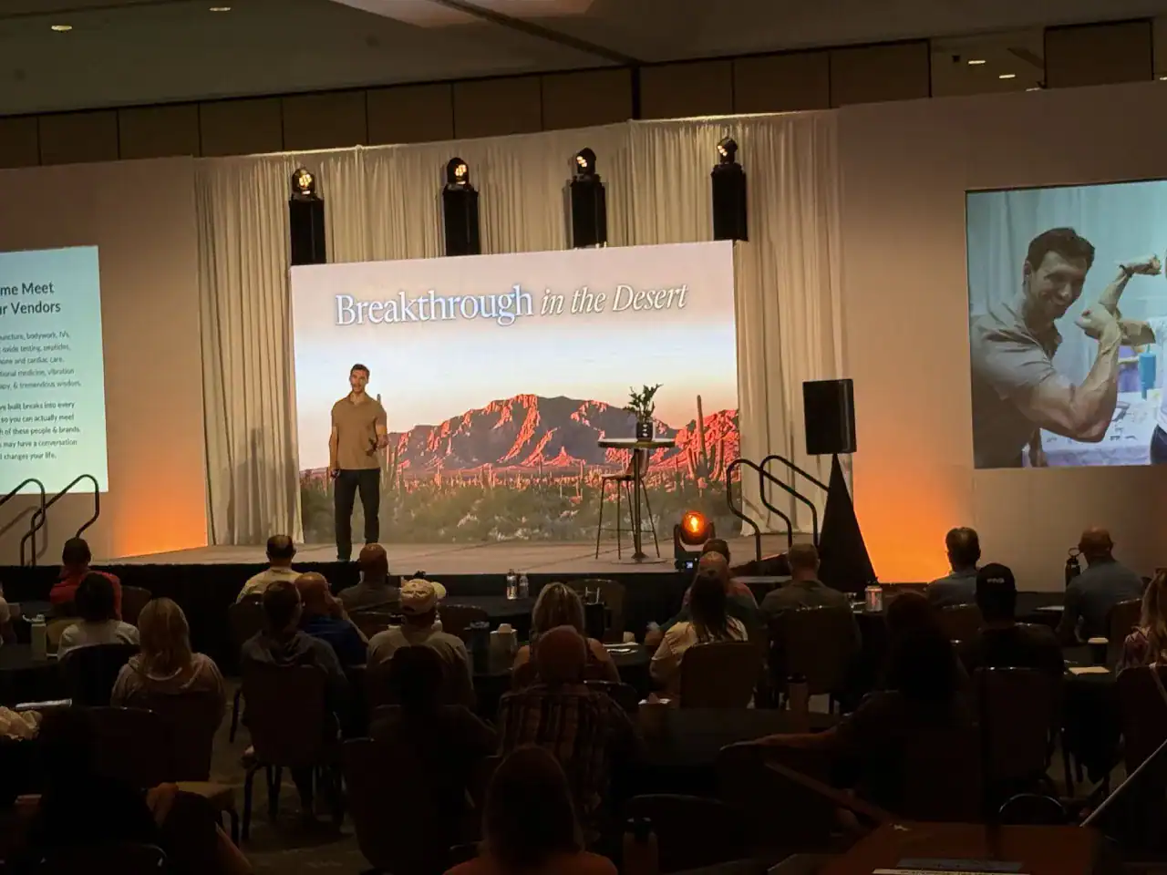 Dr. Balduzzi giving keynote address on stage in front of an LED video wall backdrop provided by Centric Events.